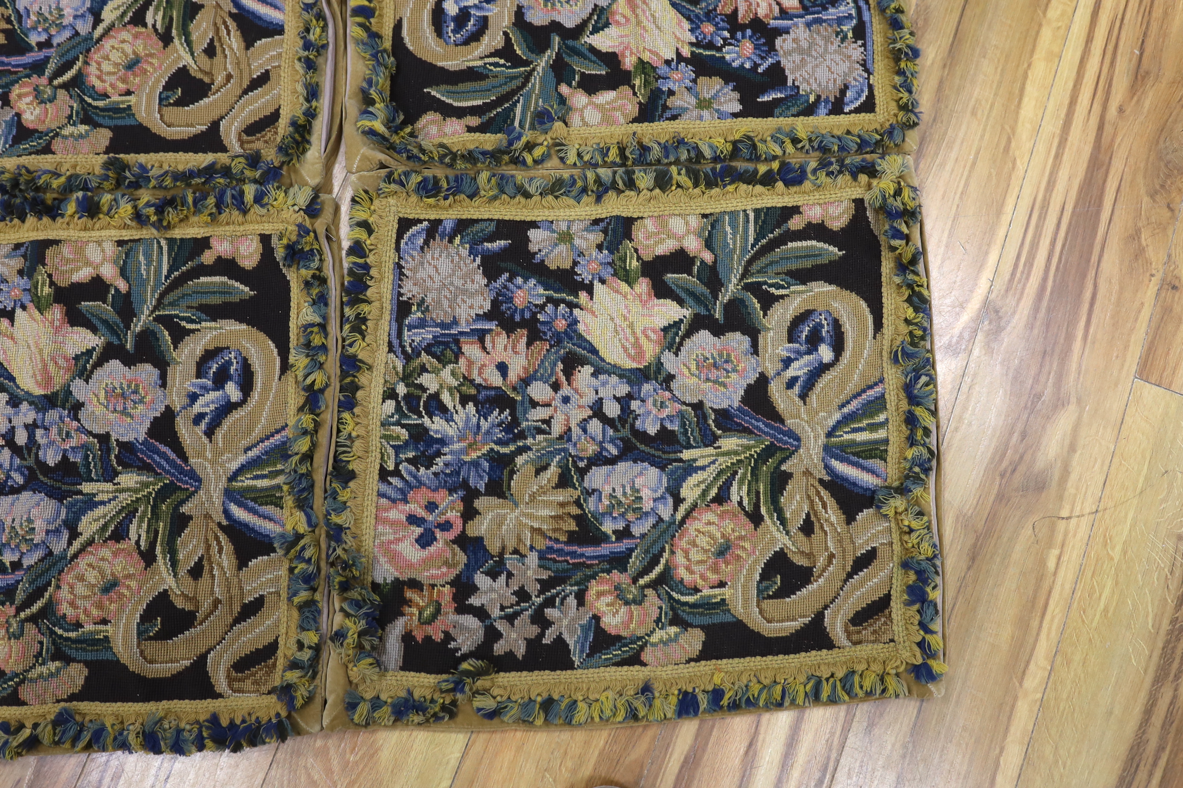 Four large woolwork cushion covers decorated with bouquets of flowers, 51 x 56cm